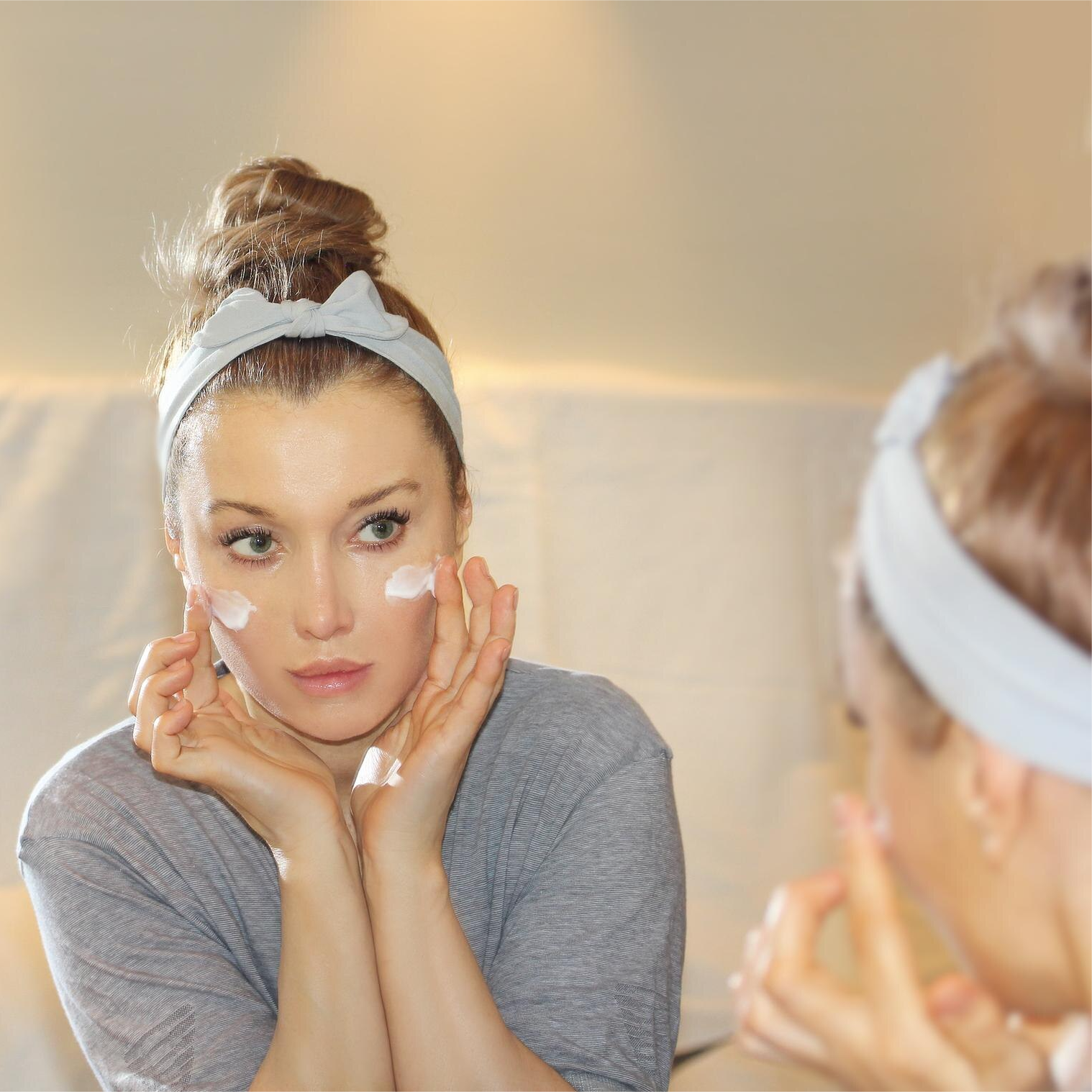 woman applying serum to face