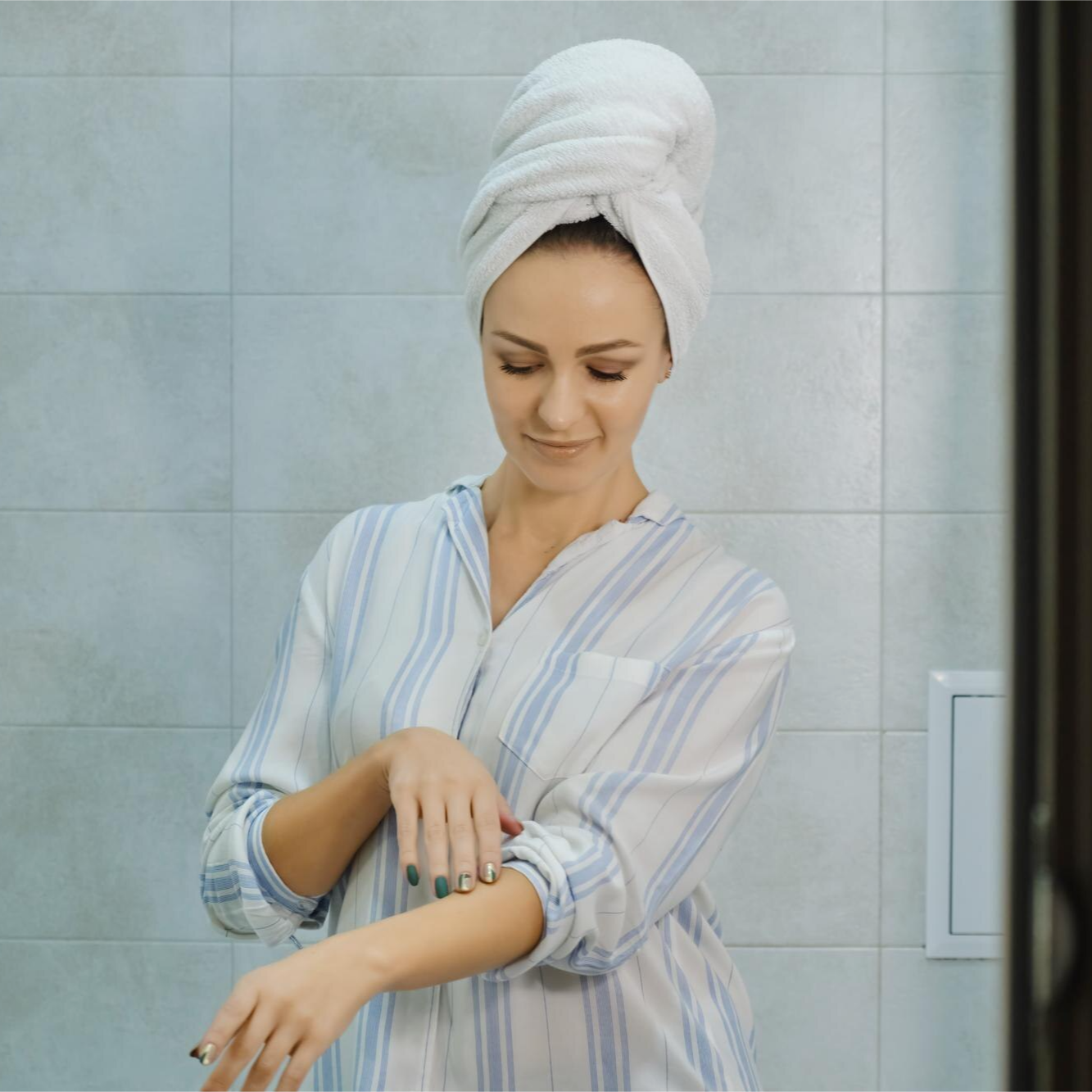 Confident woman with smooth, glowing skin touching her face gently.