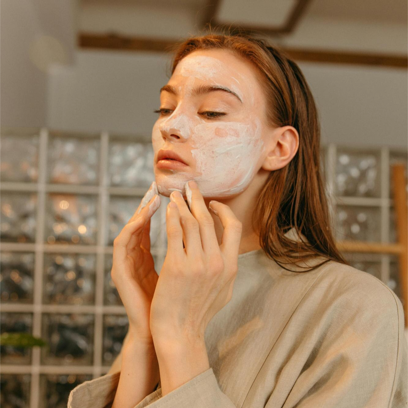 Woman applying skincare cream to her face.